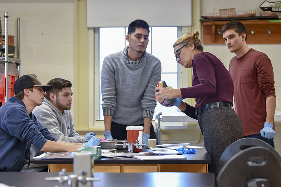 Professor instructs students on the inner workings of the heart in a biology lab.